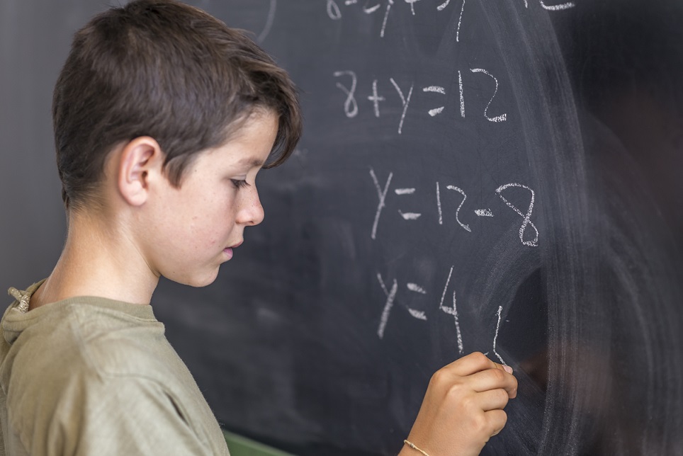 chłopiec rozwiązuje równanie matematyczne